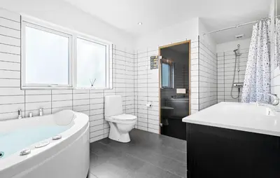 a bathroom with a tub and a toilet and a sink at Amazing Home In Løgstør With Kitchen in Løgstør