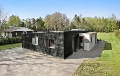 a black and grey house with a backyard at Amazing Home In Løgstør With Kitchen in Løgstør