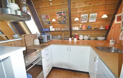 a kitchen with white cabinets and a sink at Holiday Home Golfsvinget in Farsø
