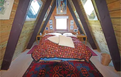 a bedroom with a bed in a wooden cabin at Holiday Home Golfsvinget in Farsø