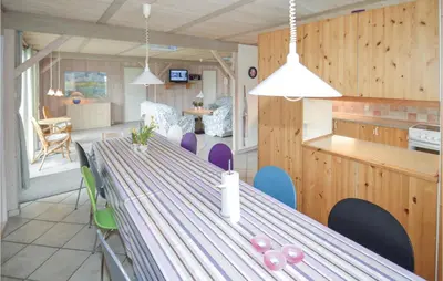 a dining room and kitchen with a long table and chairs at Holiday Home Illeris Farsø Ix in Farsø