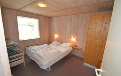 a small bedroom with a bed and a window at Holiday Home Illeris Farsø Ix in Farsø