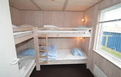 a bunk room with two bunk beds and a window at Holiday Home Illeris Farsø Ix in Farsø