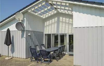 a patio with a table and chairs in front of a building at Holiday Home Illeris Farsø Ix in Farsø