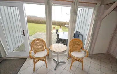 a screened porch with chairs and a table and a table at Holiday Home Illeris Farsø Ix in Farsø