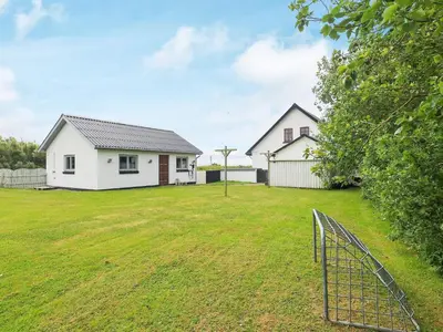 two white houses in a yard with a fence at 10 person holiday home in Vestervig-By Traum in Vestervig