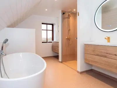 a bathroom with a tub and a sink and a mirror at 10 person holiday home in Vestervig-By Traum in Vestervig