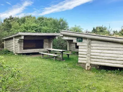 a wooden cabin with a picnic table and a bench at 10 person holiday home in Vestervig-By Traum in Vestervig