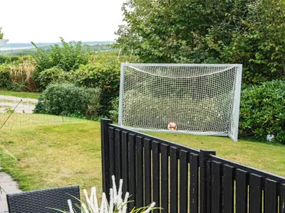a dog is sitting in front of a soccer goal at 6 person holiday home in Struer-By Traum in Struer