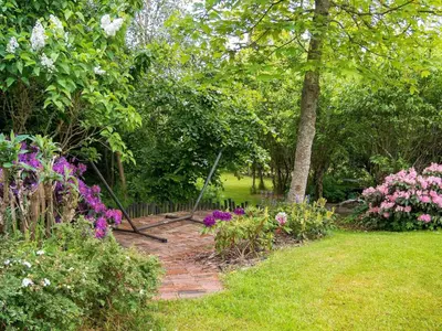 a garden with flowers and a brick path at 6 person holiday home in Struer-By Traum in Struer
