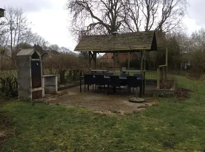 a gazebo with a table and chairs in a yard at Lundø in Højslev