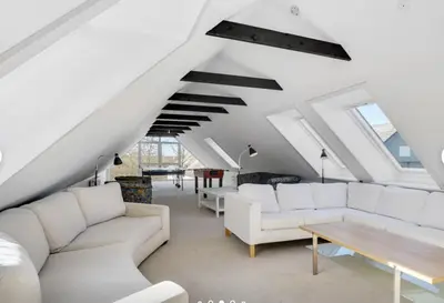 a living room with white couches and a wooden table at Lundø in Højslev