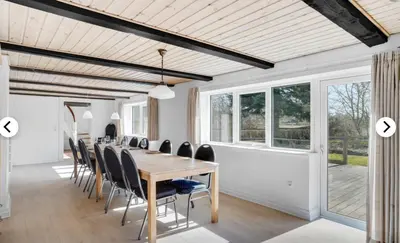 a dining room with a long table and chairs at Lundø in Højslev