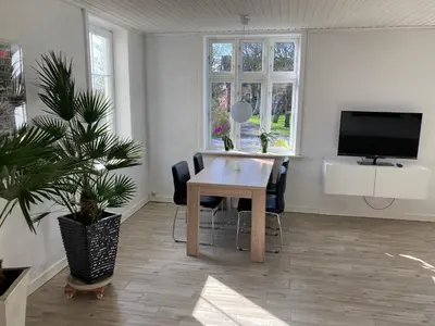 a dining room with a wooden table and a tv at Idyllic country house in Vadum