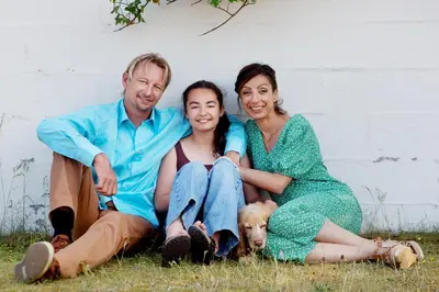 a group of three people sitting in the grass with a dog at Stone Mountain BnB in Stenbjerg