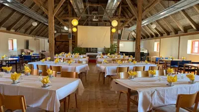 a large banquet hall with white tables and chairs at Skærum Mølle in Vemb