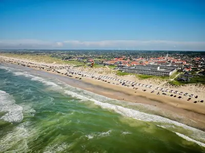 an aerial view of a beach with cars parked at 4 person apartment in holiday park Blokhus in Blokhus