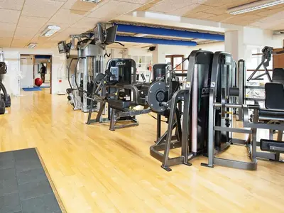 a gym with a bunch of treadmills and machines at 4 person apartment in holiday park Blokhus in Blokhus