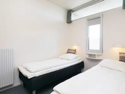 two beds in a room with a window at 4 person apartment in holiday park Blokhus in Blokhus