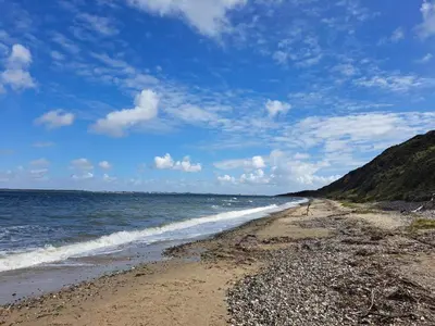 a beach with the ocean on a cloudy day at 8 person holiday home in Struer-By Traum in Struer