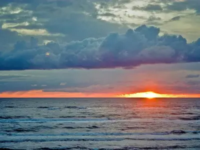 a sunset over the ocean with the sun setting at 6 person holiday home in Løkken-By Traum in Løkken
