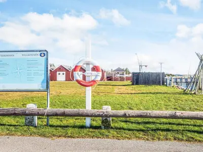 a sign sitting next to a bench in a field at 20 person holiday home in Højslev-By Traum in Højslev