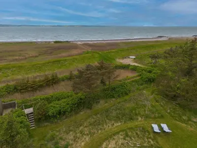 an aerial view of a beach with two white benches at 6 person holiday home in Thyholm-By Traum in Thyholm