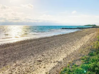 a sandy beach with the ocean in the background at 6 person holiday home in Thyholm-By Traum in Thyholm