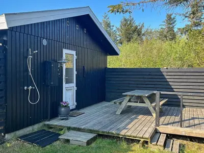 a black shed with a picnic table on a deck at 6 person holiday home in Thyholm-By Traum in Thyholm