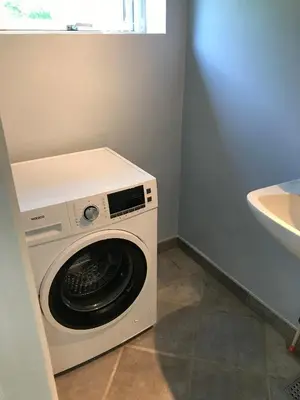 a washing machine in a bathroom next to a sink at Sommerhus på Mors in Øster Assels