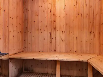 a sauna with a wooden wall with a wooden bench at Renovated Retreat with Pool - By Traum Ferienwohnungen in Thisted