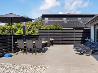 a patio with a table and chairs and an umbrella at Renovated Retreat with Pool - By Traum Ferienwohnungen in Thisted