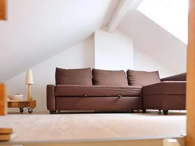 a living room with a brown couch in a attic at 8 person holiday home in Vesløs-By Traum in Vesløs