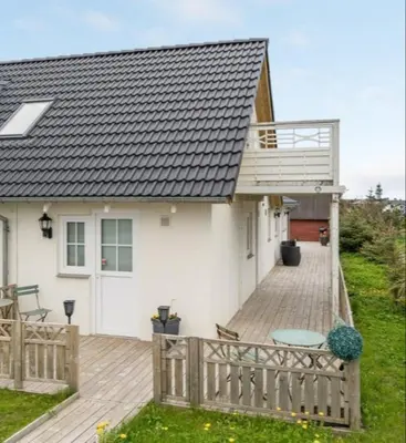 a white house with a deck and a balcony at Cold Hawaii in Torsted