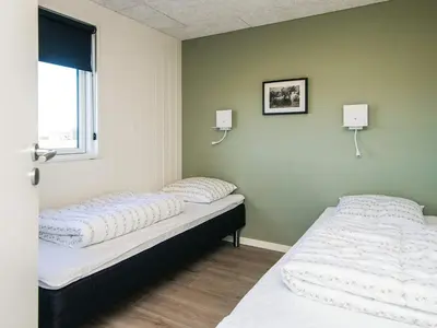 two beds in a room with green walls at Luxury Retreat with Pool - By Traum Ferienwohnungen in Harboør