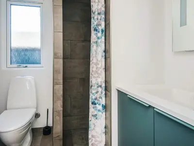 a bathroom with a toilet and a shower curtain at Luxury Retreat with Pool - By Traum Ferienwohnungen in Harboør