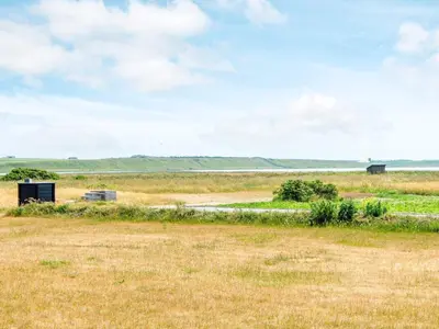 a field of grass with a road in the distance at Luxury Retreat with Pool - By Traum Ferienwohnungen in Harboør