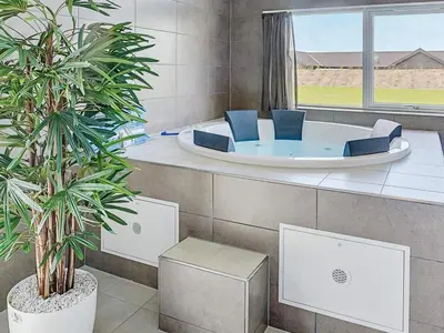 a jacuzzi tub in a room with two plants at Luxury Retreat by Limfjorden - By Traum Ferienwohnungen in Spottrup