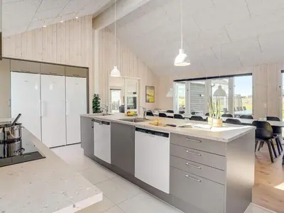 a large kitchen with white cabinets and a large island at Luxury Retreat by Limfjorden - By Traum Ferienwohnungen in Spottrup