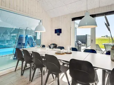 a dining room with a table and chairs and a large window at Luxury Retreat for 18 - By Traum Ferienwohnungen in Spottrup