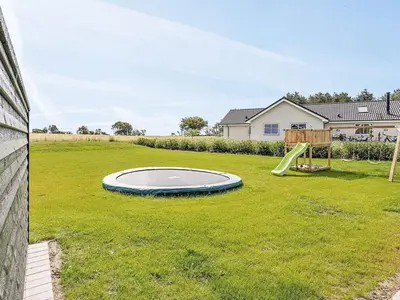 a backyard with a trampoline in the grass at Luxury Retreat for 18 - By Traum Ferienwohnungen in Spottrup