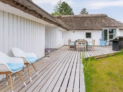 a wooden deck with chairs and a table at 10 person holiday home in Fjerritslev-By Traum in Fjerritslev