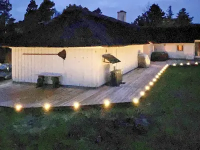 a deck with lights in a yard at night at 10 person holiday home in Fjerritslev-By Traum in Fjerritslev