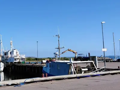 a blue boat is docked at a dock at 6 person holiday home in Vestervig-By Traum in Vestervig