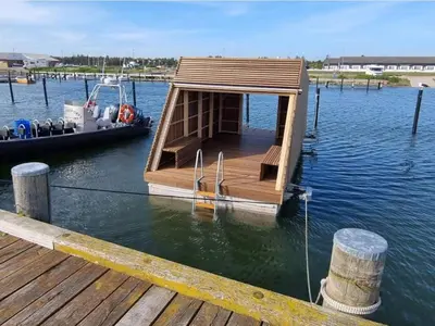 a small boat tied to a dock on the water at 6 person holiday home in Vestervig-By Traum in Vestervig