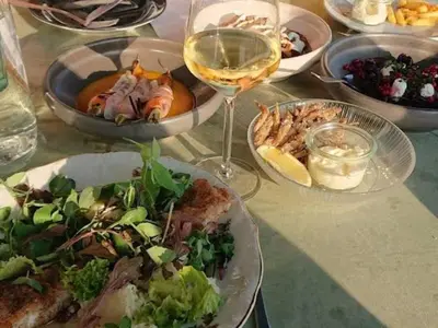 a table with plates of food and a glass of wine at 6 person holiday home in Vestervig-By Traum in Vestervig