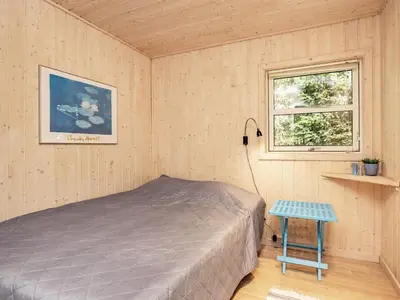 a bedroom with a bed and a window at 8 person holiday home in Blokhus-By Traum in Blokhus