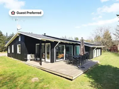 a black house with a deck and an umbrella at 10 person holiday home in Fjerritslev-By Traum in Fjerritslev