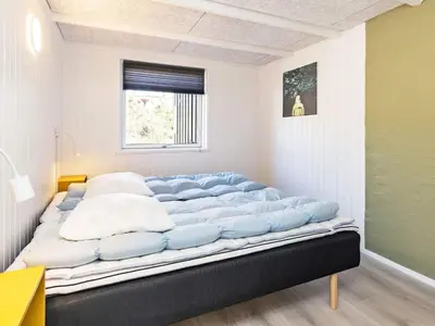 a large bed with blue pillows in a room at 10 person holiday home in Fjerritslev-By Traum in Fjerritslev