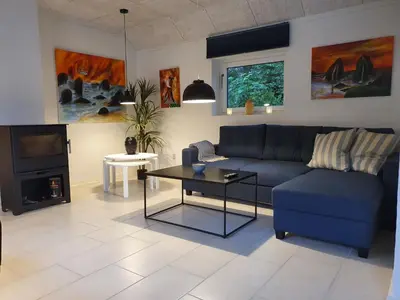 a living room with a blue couch and a tv at Airbnb-lejligheder, Villerslev in Villerslev